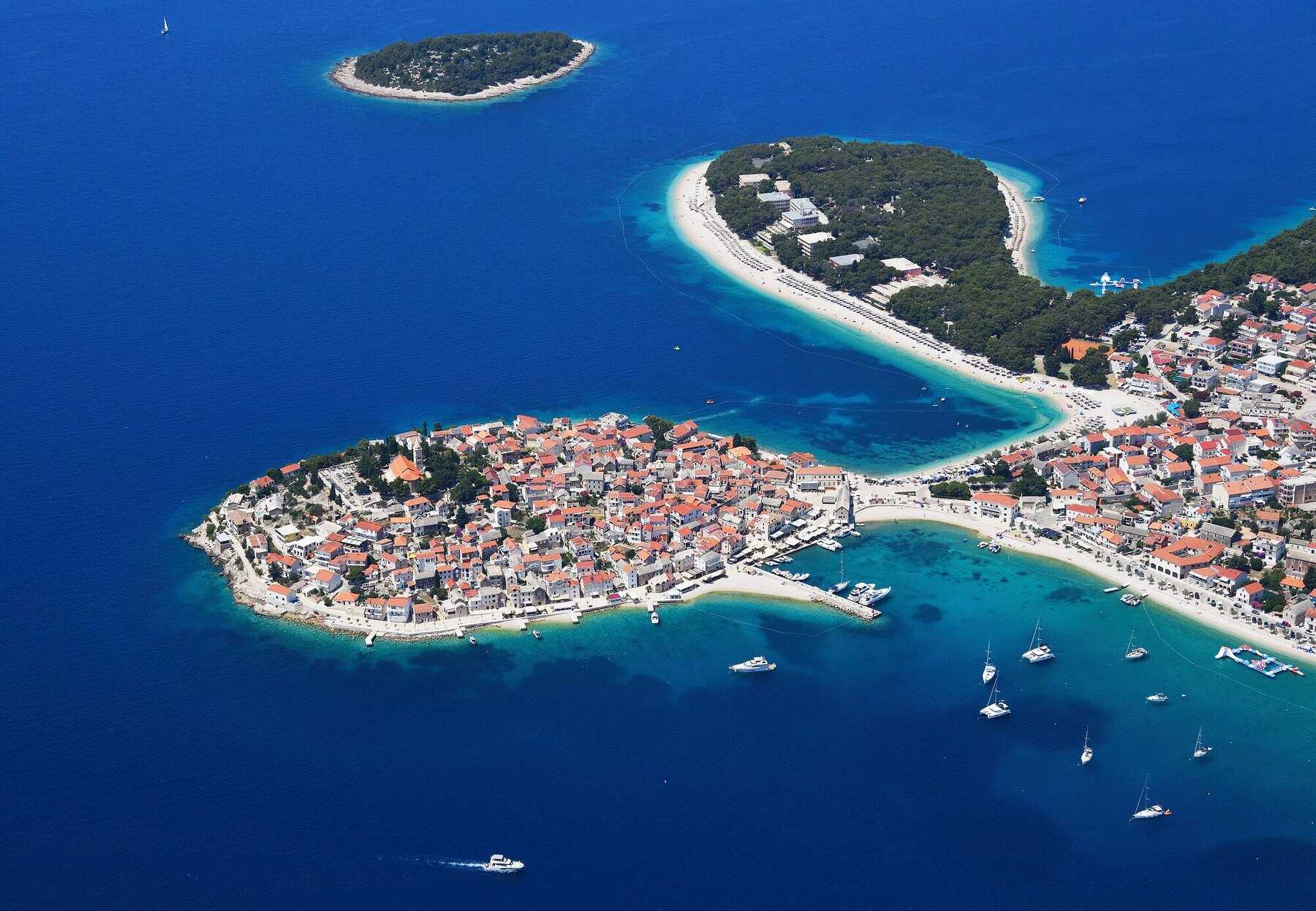 Vue aérienne de Primošten, sa vieille ville sur une presqu’île et ses plages au bord d’une mer bleu turquoise